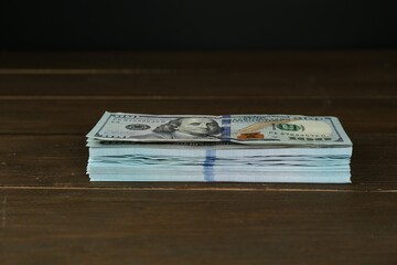 Stack of dollar banknotes on wooden table © New Africa