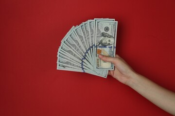Woman with dollar banknotes on red background, closeup © New Africa