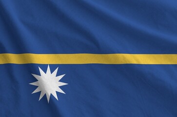 Nauru flag depicted on folded wavy fabric of old cloth close up
