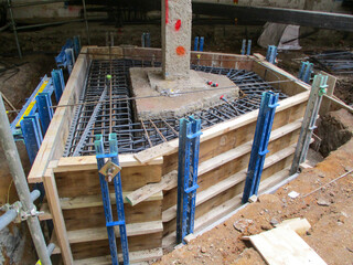 Column foundation underpinning and strengthening at a construction site with exposed foundation...