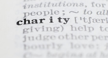 Charity definition in the dictionary close-up, shallow depth of field and selective focus.