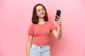 Fototapeta premium Young Ukrainian woman isolated on pink background making a selfie