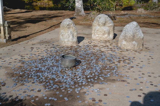 Buddha Statues with Pot for Coin Toss to Gain Luck and Good Fortune at Temple of Kinkaku-ji in Kyoto, Japan.