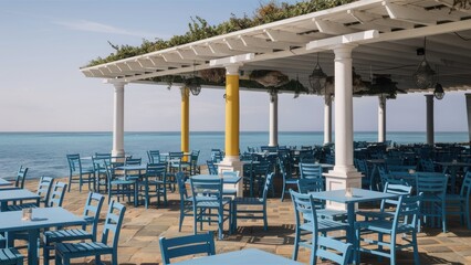 Fototapeta premium A restaurant with blue tables and chairs on a patio overlooking the ocean, AI