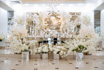reception table in a restaurant decorated with white flowers and candles..