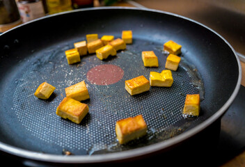 Chef at the kitchen preparing pumpkin porridge with tofu and vegetables