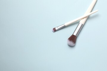 Cosmetic brushes on colored background. Set of makeup brushes