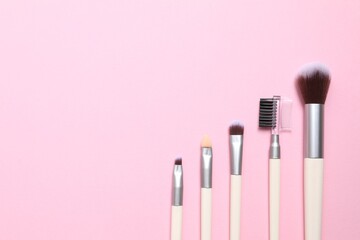 Cosmetic brushes on colored background. Set of makeup brushes