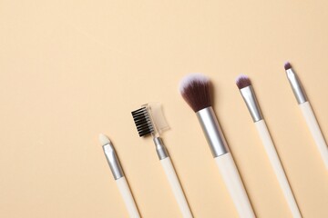Cosmetic brushes on colored background. Set of makeup brushes