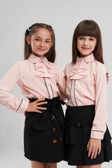 A girl of European origin in a school uniform on a white background. Smiling at the camera