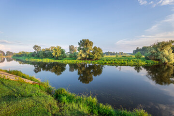 A river with trees on both sides and a clear blue sky