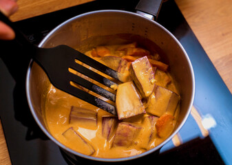 Chef at the kitchen preparing massaman curry with sweet potato and many spices
