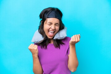 Young caucasian woman with Inflatable Travel Pillow isolated on blue background celebrating a...