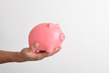 Man hand holding piggy bank for saving money isolated on white background. Saving money for retirement fund and future plan concept. Saving cost increase more income concept
