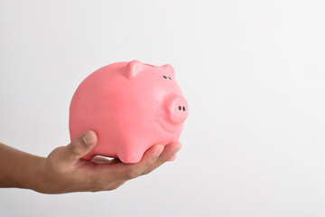 Man hand holding piggy bank for saving money isolated on white background. Saving money for retirement fund and future plan concept. Saving cost increase more income concept