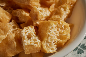 A bowl of fried, sliced tofu puffs, a classic Asian ingredient