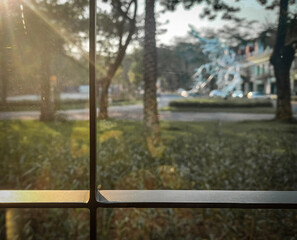 Golden evening sunlight peeks through and streams in through a glass window