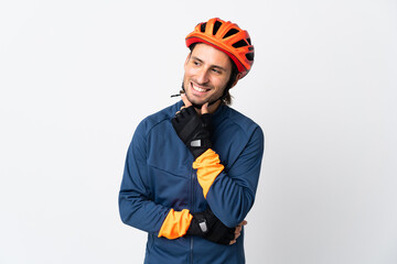 Young cyclist man isolated on white background looking to the side and smiling