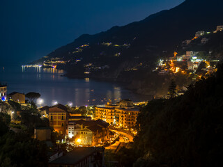 Coastal town at night with illuminated buildings