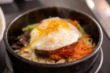 Bibimbap, a Korean rice dish. It is cooked rice mixed with namul, gochujang, egg and meat.