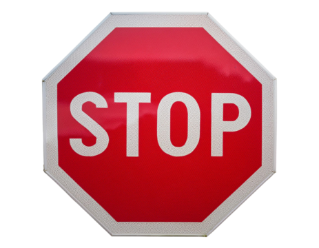 Red octagon stop sign close-up isolated on white background, symbolizing traffic regulation and safety.