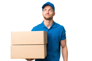 Delivery caucasian man over isolated background and looking up