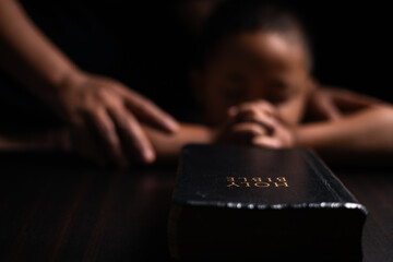 A mother teaches her child about Jesus Christ and the Christian faith, reading the Bible together...