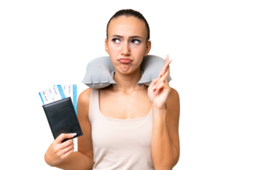 Young Arab woman with Inflatable Travel Pillow over isolated background with fingers crossing and wishing the best