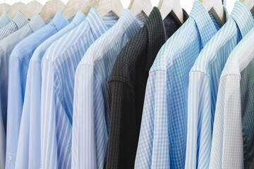 A row of shirts are hanging on a clothesline, with some being blue and some being white
