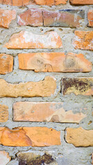 brick wall facade texture texture background. A textured background of decayed old red and white bricks in an exterior uneven wall of a house with dirty whitewashed worn plaster. Brick wall