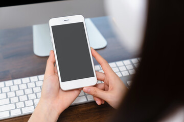 Hand holding smartphone mockup of blank screen for graphic display montage.