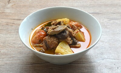 spicy boiled roasted duck meat with pineapple and tomato in coconut milk curry soup on bowl