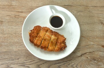 Tonkatsu crispy fried pork with flour dipping swwt soy sauce on plate