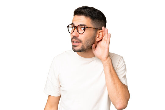 Young handsome caucasian man over isolated chroma key background listening to something by putting hand on the ear