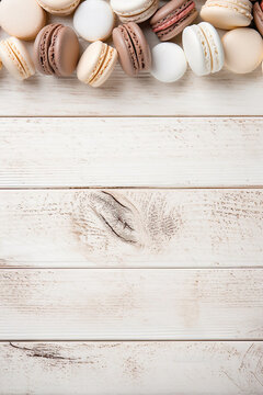 macarones on white wooden ground, space for text, food background