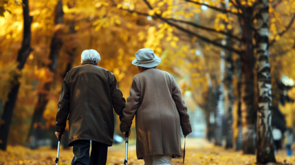 National Senior Citizens Day. Horizontal banner. An elderly man and woman walk through an autumn park holding hands. Copy space. Care for the elderly concept