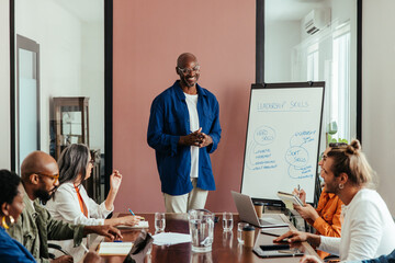 Casual leadership training workshop in modern office boardroom with diverse team