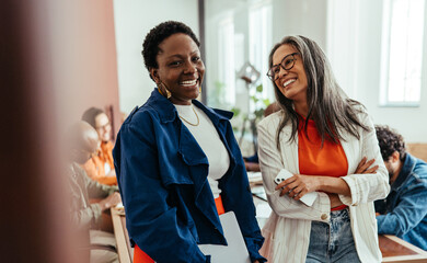 Creative co-working environment with diverse women colleagues chatting and laughing in a vibrant workplace