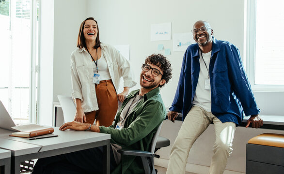 Diverse happy team of employees enjoying work at modern corporate office