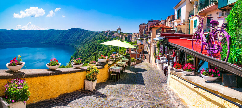 Сharming Floral Street in Castel Gandolfo with Vintage Bicycle Decor and Restaurant Tables.  Panoramic View of Volcanic Lake Albano Crater, Authentic Italian Village Castelli Romani, Italy