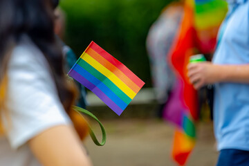 Celebration of pride month in Amsterdam, Peoples with mimi rainbow flags on backpack for street...