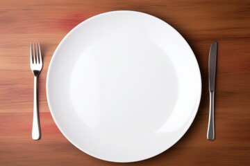 Empty Plate on Wooden Table: A clean, white plate awaits its culinary destiny, nestled between a fork and knife on a warm, rustic wooden table. This minimalist image evokes anticipation and the promis