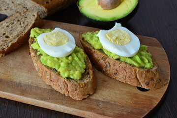 a slice of bread with eggs and avocado on it close up