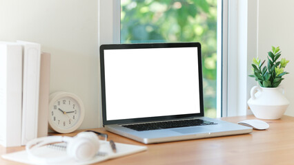  minimalist home office setup featuring a laptop with a blank screen on a wooden desk.
