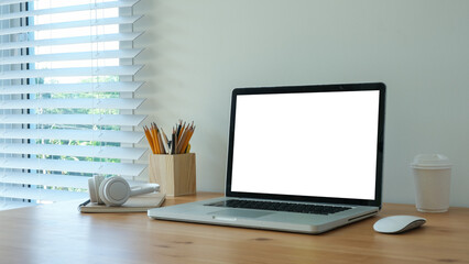  minimalist home office setup featuring a laptop with a blank screen on a wooden desk.