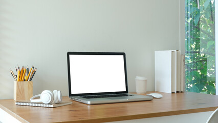  minimalist home office setup featuring a laptop with a blank screen on a wooden desk.