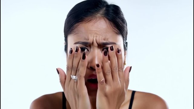 A woman with a surprised expression on her face. She is wearing a black tank top. Concept of shock or disbelief