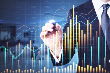 Businessman analyzing stock market data on a transparent screen with financial graphs.