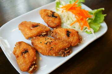 fried chicken wings on white plate wooden background