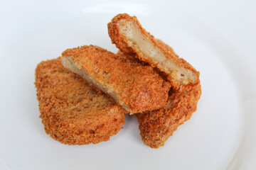 Sliced fried chicken nugget on white plate, isolated on white background